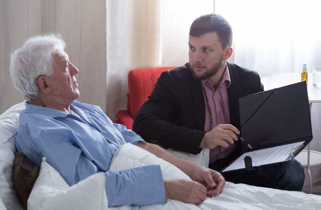 men sick in hospital bed talking to son